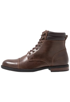 Brown leather lace-up ankle boot with padded collar, stitched detailing, and low stacked heel on a white background.