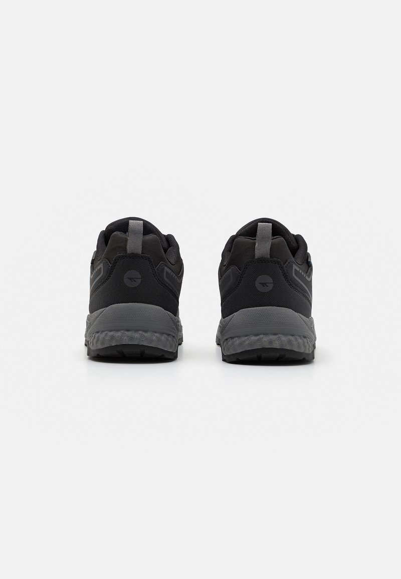 Schwarze Sportschuhe mit gepolstertem Schaft, strukturiertem Mesh-Obermaterial und einer Gummisohle mit grauem Mittelsohlenelement und Fersendetails.