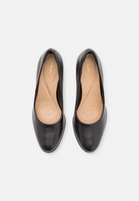 Scarpe décolleté in pelle nera con punta rotonda, soletta imbottita con perforazioni e finitura liscia. Marchio visibile all'interno.