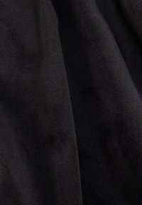 Czarna tkanina o gładkiej, miękkiej fakturze, lekko refleksyjnej powierzchni, z widocznymi fałdami i różnicami odcieni.