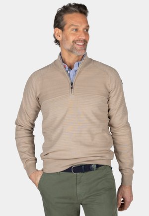 Beige zip-nek trui met gestructureerde horizontale strepen, geribde manchetten en onderkant. Draag het over een lichtblauw overhemd met kraag en knopen.
