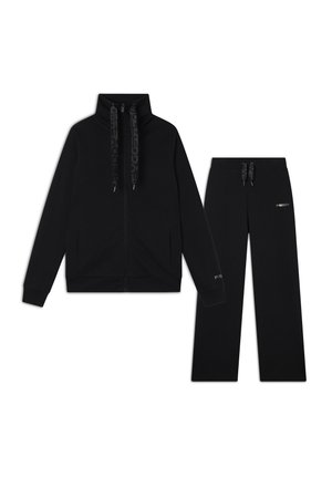 Felpa nera con zip e colletto alto, caratterizzata da cordini con motivo e tasche laterali. Pantaloni sportivi neri abbinati con vita elastica e logo.