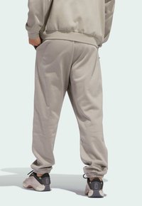 Helle graue Jogginghosen aus weicher Baumwolle, mit elastischem Bund und Bündchen, seitlichen Taschen und einer lockeren Passform.