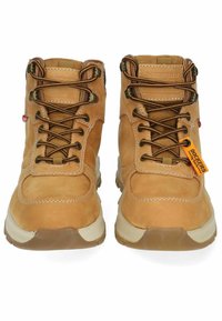 Las botas de senderismo de cuero marrón presentan un diseño de cordones, un cuello acolchado, suela de goma y una etiqueta que muestra el nombre de la marca. La costura es visible a lo largo de las costuras.