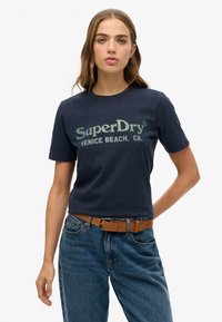 Mørkeblå bomulds T-shirt med rund hals og korte ærmer, prydet med teksten "SuperDry VENICE BEACH. CA." i lyseblå og grøn skrift.