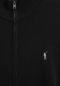 Maglione nero a maglia con zip, collo a coste e piccolo logo polo ricamato bianco sul petto.