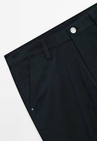Black trousers made of textured fabric, featuring a flat front, button closure, and two side pockets with silver accents.