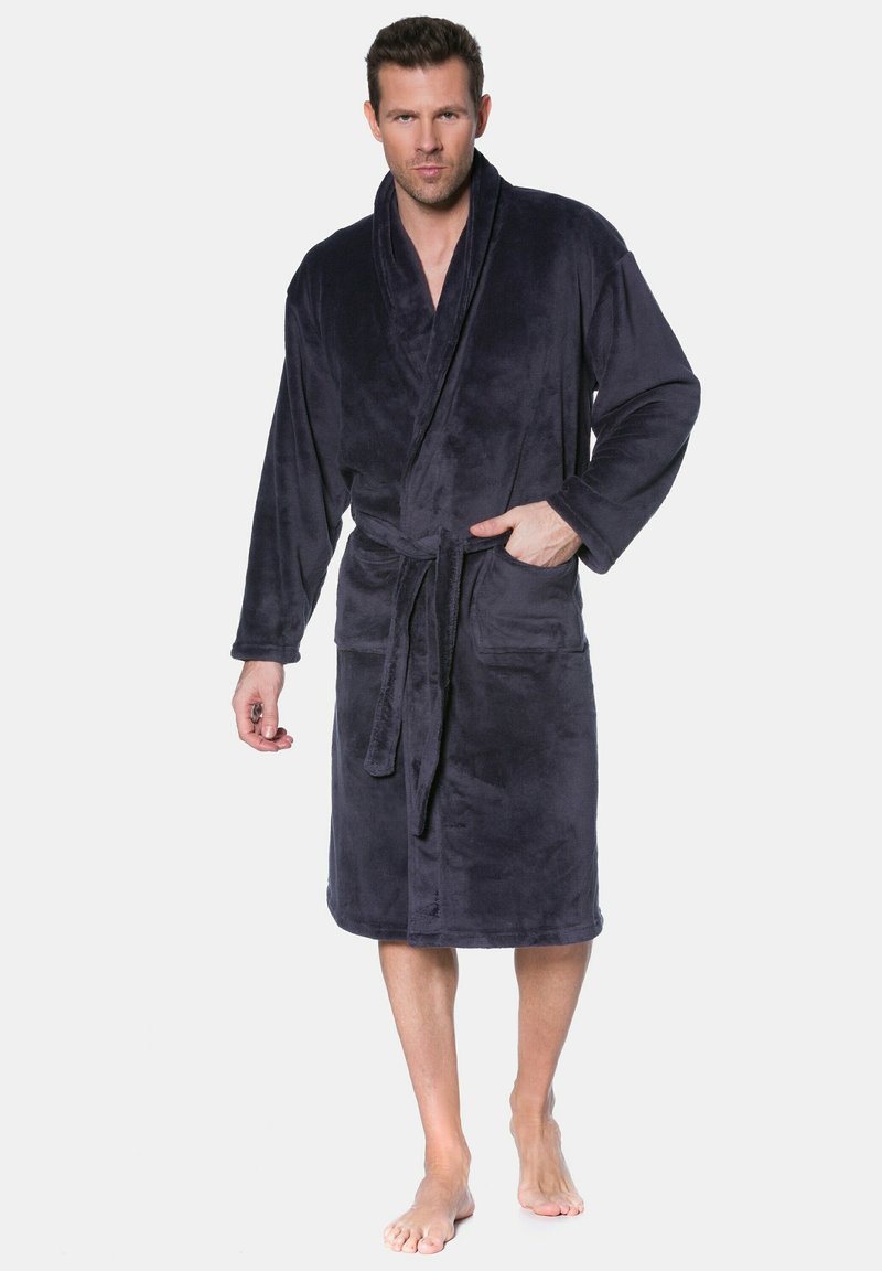 Accogliente accappatoio blu navy scuro realizzato in morbido e pelucchoso materiale; presenta un colletto a scialle, maniche lunghe e una vita con cintura, corredato di due tasche laterali.