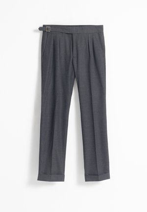 Pantalones ajustados de color gris oscuro con cinturón con hebilla lateral, pliegues en la cintura, bolsillos laterales y dobladillos en los tobillos, colgando sobre un fondo blanco.