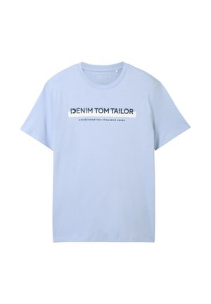 Világoskék pamut póló, rövid ujjakkal és kerek nyakkivágással. Az elülső grafikán szerepel a "DENIM TOM TAILOR" felirat és "2007-ben alapítva".