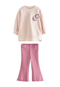 Ljusrosa bomullströja med broderade detaljer av sol och måne, kombinerad med rosa ribbade utsvängda byxor. Mjuk textur, avslappnad design.