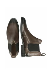 Botas Chelsea de cuero marrón con acabado brillante, paneles laterales elásticos y una pestaña de tirador. Presentan un tacón bajo apilado y una textura suave.