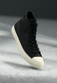 Sneaker alta nera in tessuto texture, suola in gomma bianca, punta rinforzata e design tradizionale con lacci.