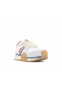 Sportowe sneakersy w białym kolorze z szarymi akcentami, z czerwonymi i niebieskimi paskami, z teksturowaną beżową podeszwą oraz związaniami.