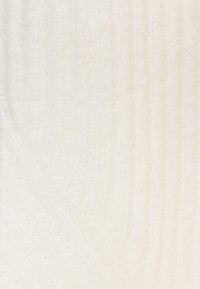 Biały tkanina o fakturze, miękka w dotyku, z subtelnymi ukośnymi wzorami dzianiny, tworzącymi ciepły i przyjazny wygląd.