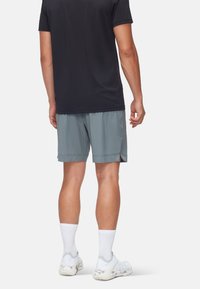 Ljusblå träningsshorts med sidsprund, tillsammans med en svart kortärmad t-shirt. Outfitten kompletteras med vita crew-strumpor och sneakers.