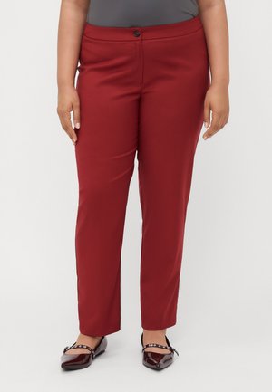 Rote Slim-Fit-Hosen mit glatter Textur, einreihiger Knopfverschluss und maßgeschneidertem Design. Getragen mit glänzenden burgunderfarbenen Ballerinas.