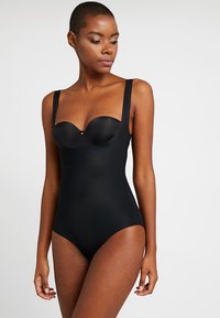 Μαύρο ολόσωμο μαγιό φτιαγμένο από λείο ύφασμα, με φαρδιά τιράντες και δομημένο μπούστο, καθώς και μια διακριτική χρυσή λεπτομέρεια στο κέντρο.