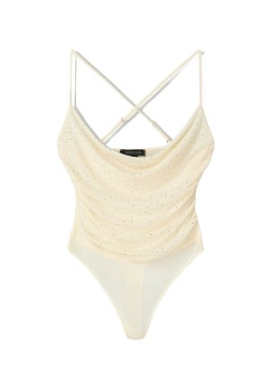 Cream bodysuit with cowl neckline, cross-back straps, and sparkling silver dots. Smooth fabric with a high-cut leg design.