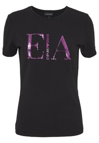Svart kortärmad t-shirt i bomull med rund halsringning. Utsmyckad med stora rosa paljetter som bildar bokstäverna "E.A." och "EMPORIO ARMANI."