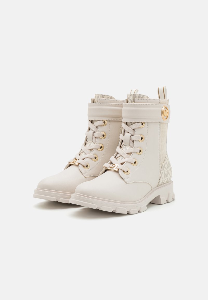 Bottines en cuir blanc avec un col rembourré, quincaillerie dorée et accents de logo texturé beige sur les côtés. Semelle en caoutchouc épaisse.