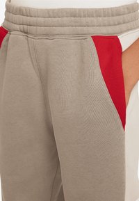 Nike Sportswear AIR PANT UNISEX - Träningsbyxor - khaki/light orewood brown/university red