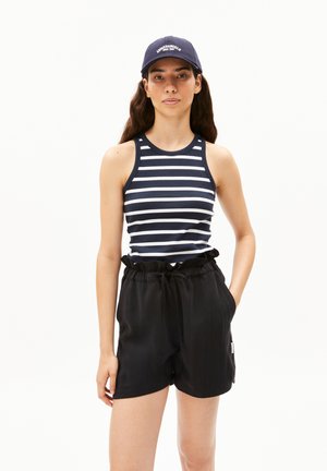 Débardeur sans manches bleu marine et blanc rayé associé à un short noir taille haute. Le short possède un cordon de serrage et des poches latérales.