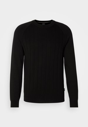 Black knit sweater featuring vertical ribbed texture, crew neckline, and long raglan sleeves. Includes subtle logo at the hem.
