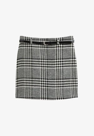 Zwart-witte geruite rok met een zigzagpatroon, voorzien van een zwarte riem en zilveren gesp, gemaakt van textuurstof.