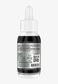 Tropfflasche mit 30 ml schwarzem Serum. Merkmale eines klaren Glasgehäuses mit einem weißen Tropfer und einem detaillierten Produktetikett mit QR-Code.