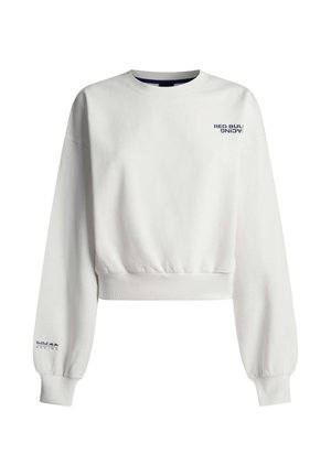 Biała krótka bluza z granatowymi logo „Red Bull Racing” na piersi i lewym rękawie, z prążkowanymi mankietami i dolnym wykończeniem.