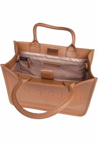 Sac fourre-tout en cuir tan avec deux poignées, doté d'un intérieur matelassé et d'une poche zippée. Logo subtil embossé sur le devant.