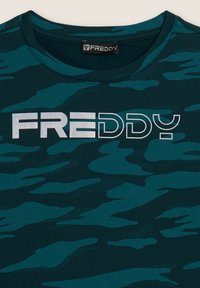 T-shirt camouflage in teal con colletto rotondo, maniche corte e un audace logo bianco "FREDDY" sul davanti. Tessuto morbido e testurizzato.