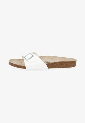 White sandal with a wide strap, silver buckle detail, textured cork footbed, and white rubber sole. Simple design, lightweight construction.