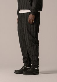 BLKVIS - ALLOVER TRACK PANTS UNISEX - Tracksuit bottoms - black Thumbnail Image 1