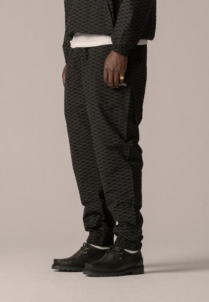 ALLOVER TRACK PANTS UNISEX - Tracksuit bottoms - black