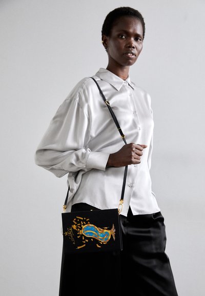 Schwarze Handtasche mit einem Tragegurt, die ein farbenfrohes, abstraktes Design mit goldenen Akzenten aufweist. Glatte Textur, rechteckige Form und klare Handwerksdetails.