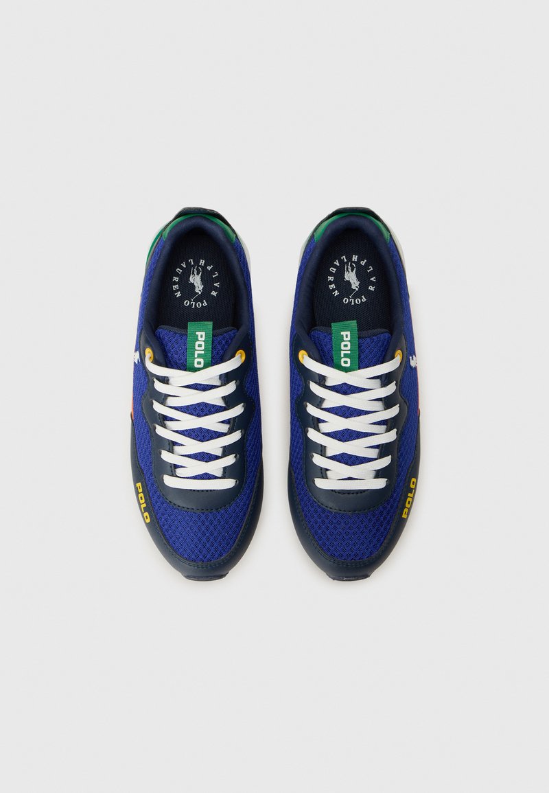 Baskets en maille bleu marine avec des lacets blancs, des accents verts et jaunes, et une marque "POLO" sur les côtés. Embout arrondi et col rembourré.