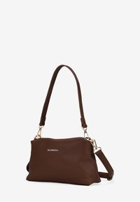 Bolso de mano de cuero marrón con un acabado texturizado, correa ajustable y detalles de hardware en dorado. Presenta el nombre de la marca "BOSANOVA" en la parte frontal.