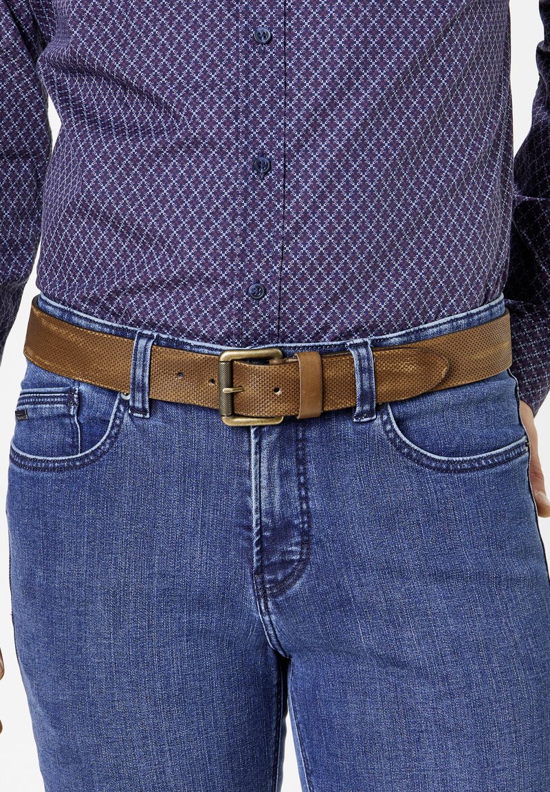 Brauner gewebter Ledergürtel mit strukturierter Oberfläche, ausgestattet mit einer Metallschnalle, getragen über einem blau karierten Hemd und blauen Jeans.