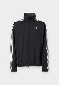 Črn vetrovka z visokim ovratnikom, belim trojnamenskim dizajnom na rokavih, elastičnimi manšeti in robom, s majhnim logotipom na prsih.