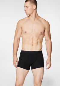 Czarne bawełniane slipy typu boxer z dopasowanym krojem, posiadające miękką gumkę w talii. Gładka struktura i minimalistyczny design, idealne do codziennego noszenia.