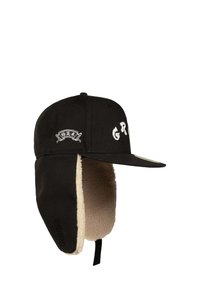 Gorra negra con orejeras, con un forro de fleece beige. En la parte delantera aparecen las letras "G R" en bordado blanco y un parche con logo.