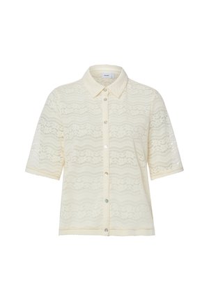 Blouse courte en dentelle crème à manches courtes avec col pointu et boutons devant, présentant un motif ondulé et floral sur toute la surface.