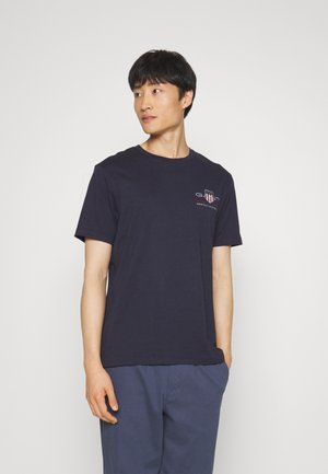 Tricou din bumbac de culoare albastru marin, cu mâneci scurte. Are un mic logo imprimat în zona stângă a pieptului. Design simplu cu guler rotund.