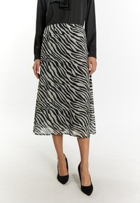 Gonna midi a strisce zebrate in bianco e nero realizzata in tessuto leggero. Presenta un elastico in vita e una silhouette fluida.