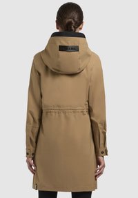 Beige waterdichte jas met een capuchon en zwarte kraag, met een getailleerde taille, knoopmanchetten en een logo op de rug.