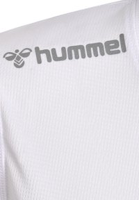 Hvid sportsbil med en ribbet tekstur, med et gråt "hummel" logo og et bi-grafik nær halsudskæringen. Letvægtigt stof.
