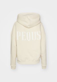 Svetlo bež št hoodie z mehkimi teksturami, ohlapen kroj in veliko belo besedilo "PEQUS" na hrbtni strani. Ima kapuco z vrvico in rebraste manšete.