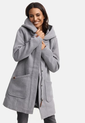 Manteau en polaire gris avec une grande capuche, de grandes poches avant et une ouverture zippée. Présente des accents en cuir marron sur les poches. Texture douce.